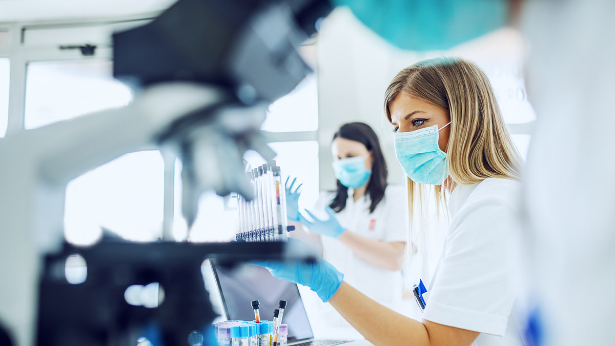 Two woman in lab coats using lab equipment