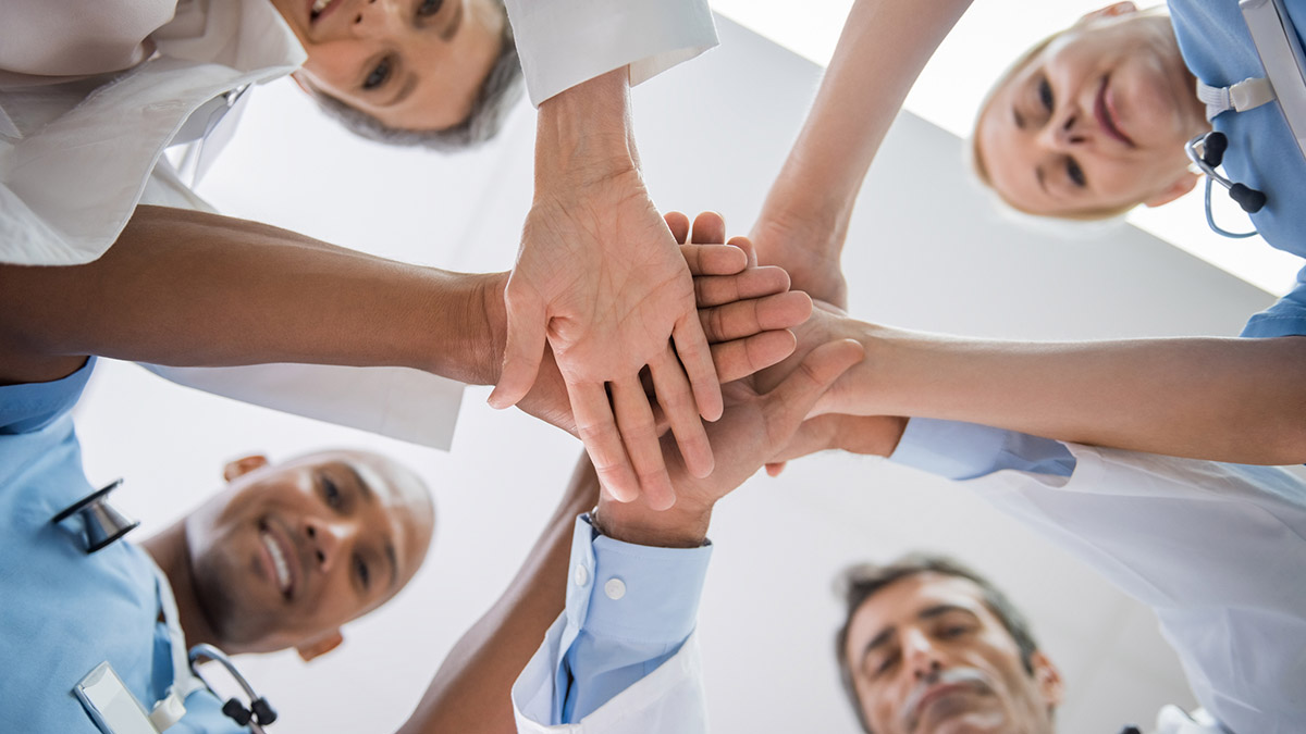 A group of doctors and nurses in a team huddle
