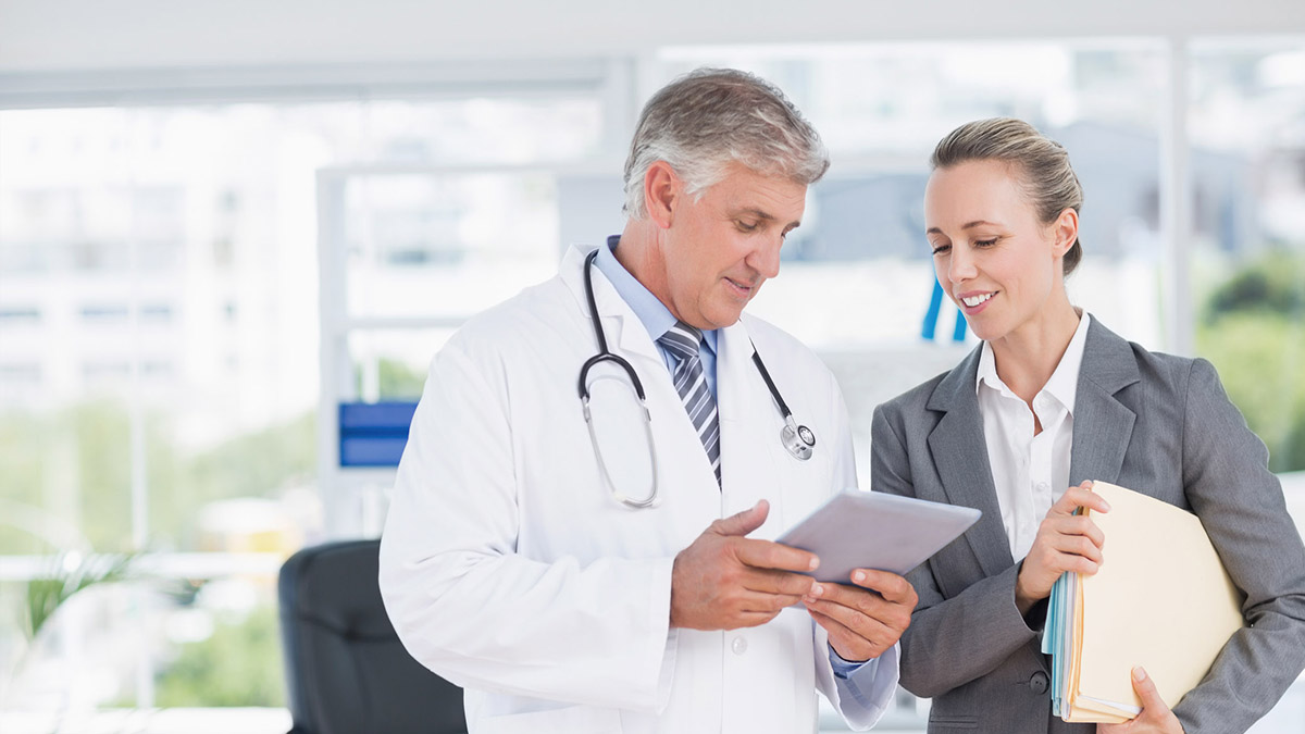 Doctor and woman looking at tablet