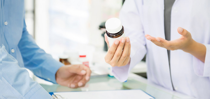 Pharmacist handing a prescription to a patient